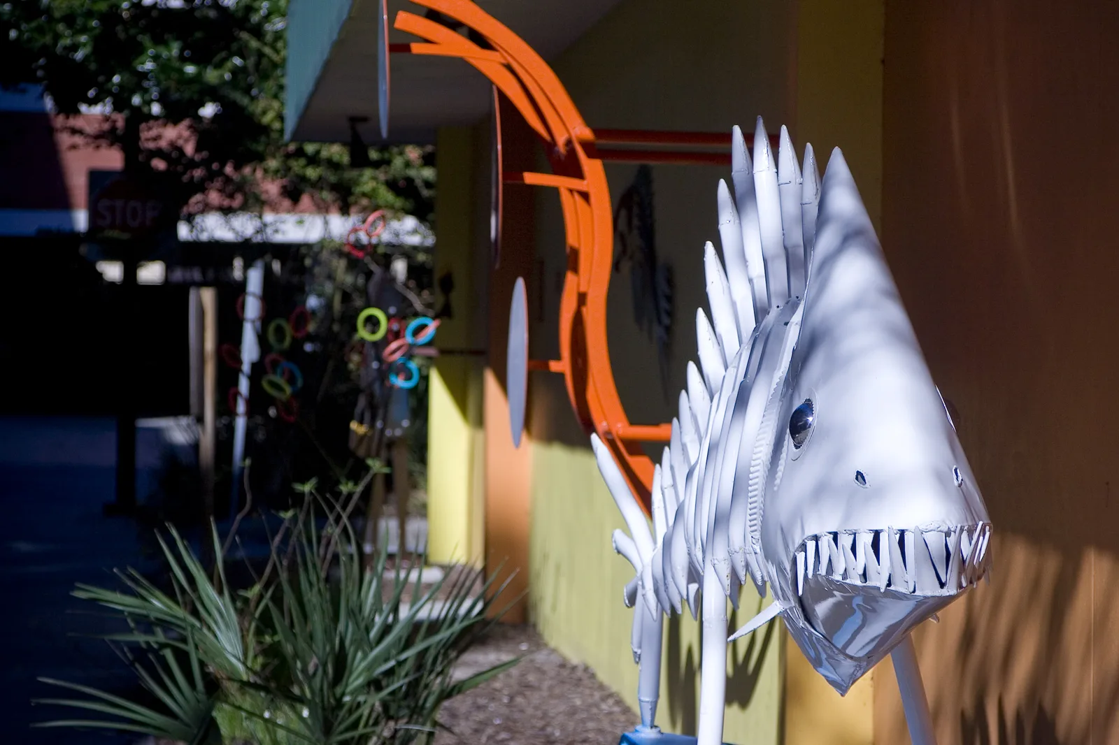 Metal fish sculptures and other public art along a sidewalk in downtown Gainesville.
