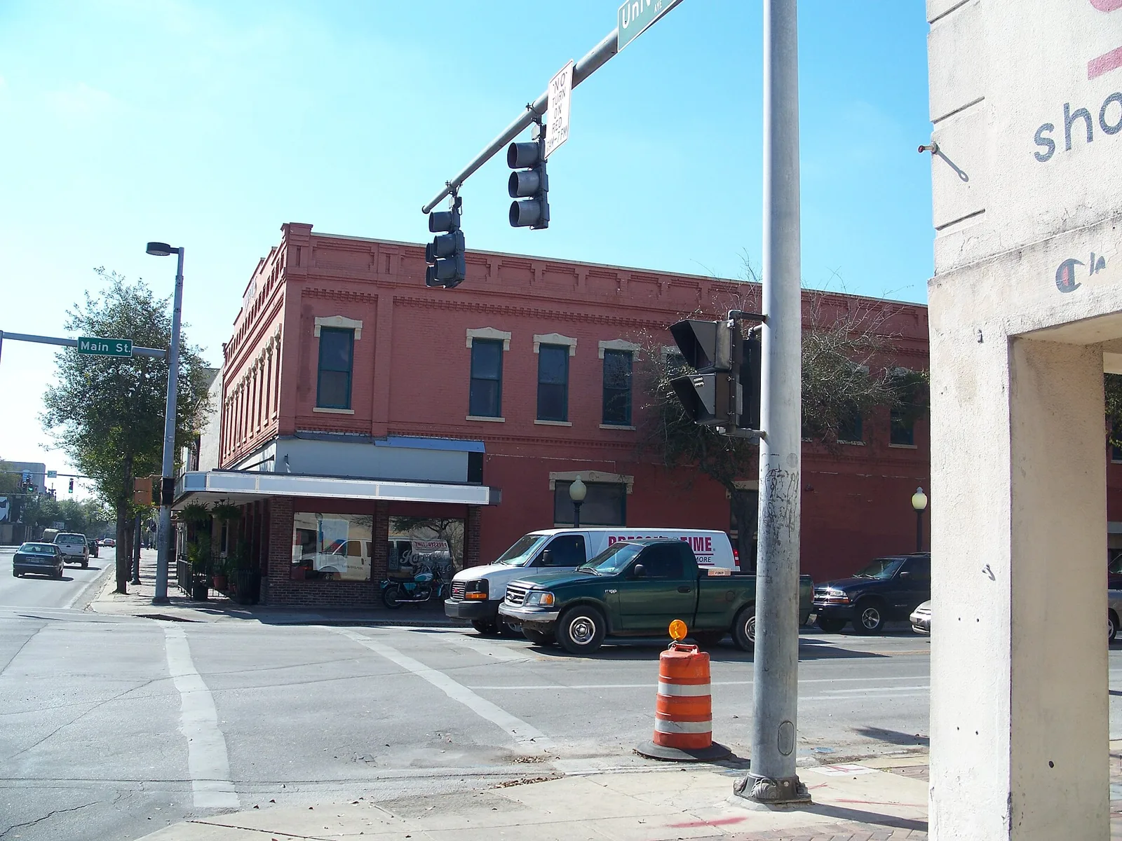 A brick storefront building at Main Street and University Avenue in downtown Gainesville.