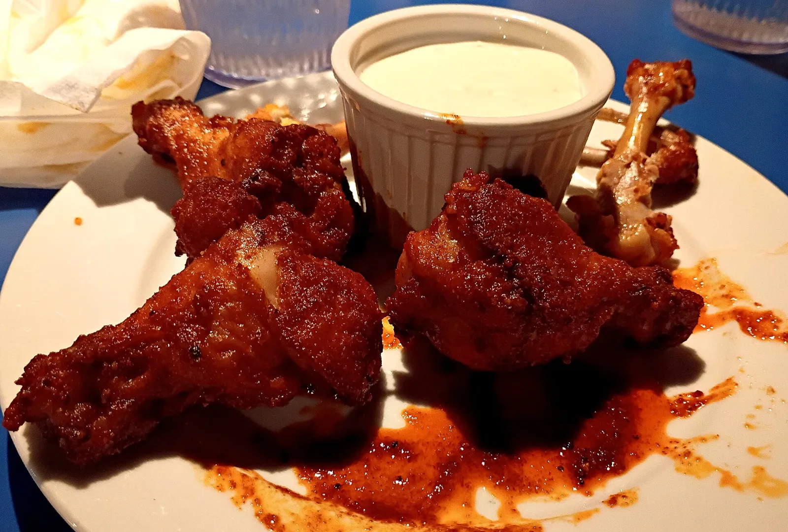 A plate of chicken wings with a cup of dressing. The photo was not taken at a Gainesville restaurant.